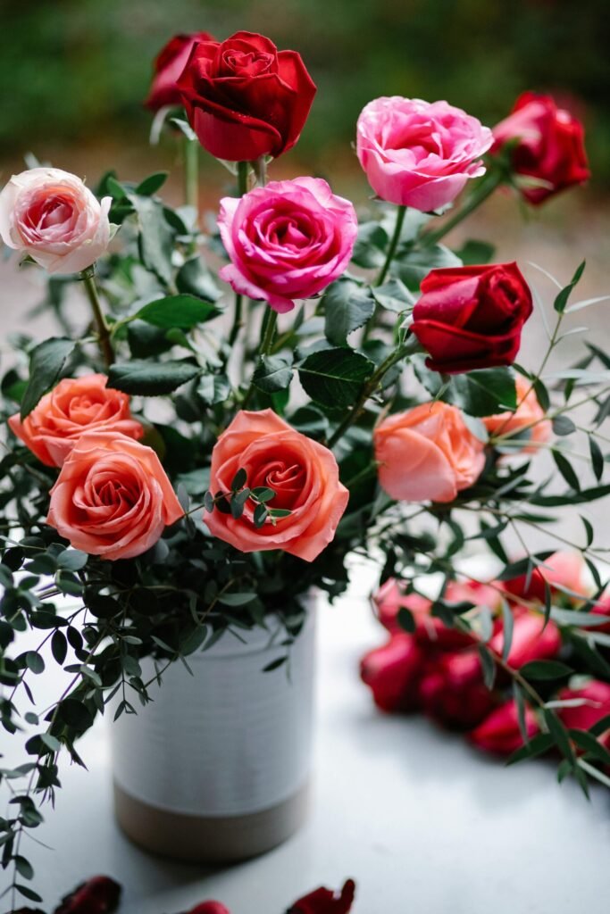 pexels-photo-6765922-6765922 Beautiful arrangement of red, pink, and orange roses in a vase.